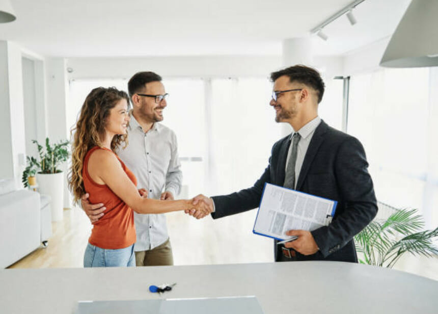a couple shaking hands with their real estate agent